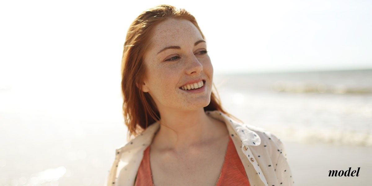 Woman Smiling and Glancing Sideways at Beach